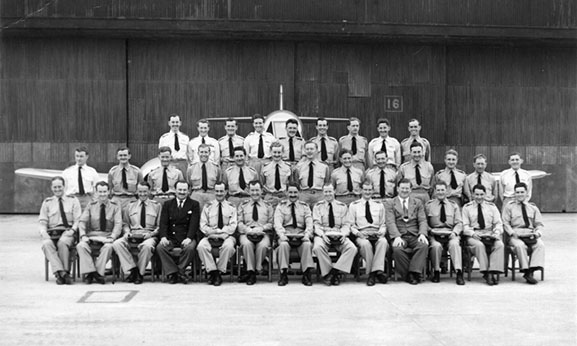 A formal group portrait of 77 Squadron RAAF pilots taken in front of one of the Squadron's new Meteor F.8 jet aircraft at Iwakuni, Japan, April 1951. This marked the commencement of their conversion from the P-51D Mustang to its replacement. Max Scannell is on front row, third from the left. 