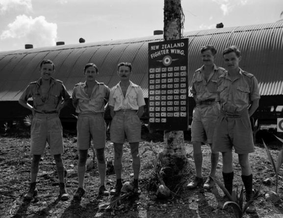Group of Number 18 Squadron RNZAF officers with the New Zealand Fighter Wing scoreboard, Ondonga, New Georgia, November 1943. Image ref PR2367 ©RNZAF Official.