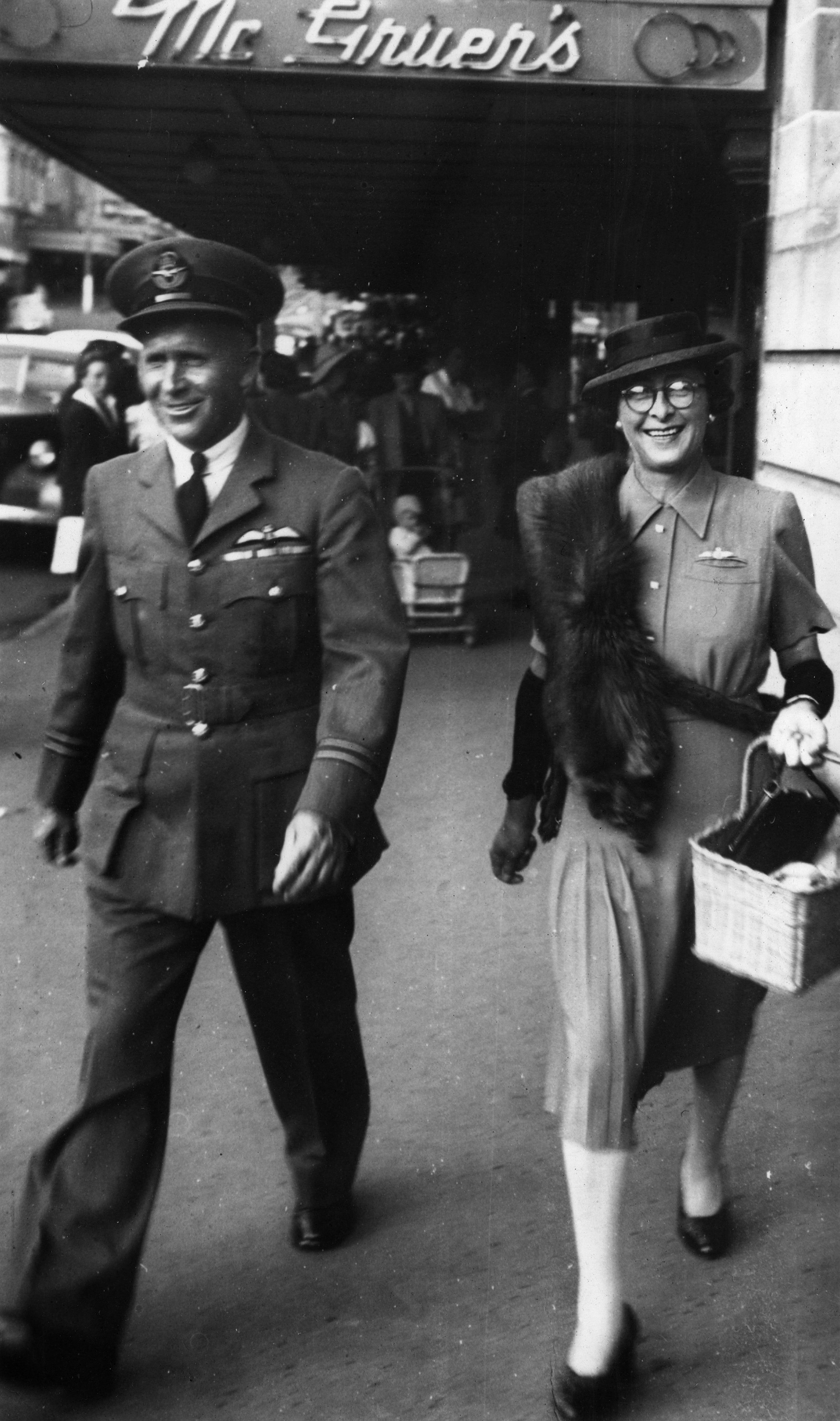 Flight Lieutenant HC Leese and his wife walking in a street in New Plymouth.