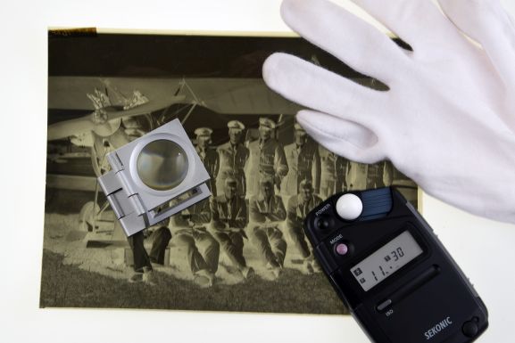 Still life featuring a negative, light meter, gloves and a magnifier. Air Force museum of New Zealand.