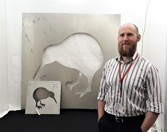 Collections Technician Murray McGuigan with the original stencils for the application of the RNZAF kiwi roundel, now in the collection of the Air Force Museum of New Zealand.