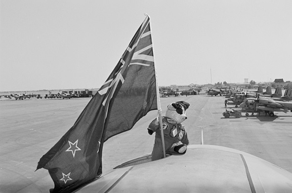 No. 75 Squadron RNZAF mascot, Henry Fanshaw, 'on deployment' with No. 40 Squadron, proudly waving a New Zealand flag atop a 40 Squadron Hercules. Riyadh, Saudi Arabia.
In the background are US Army Grumman Mohawk aircraft. Operation Fresco, Feb-Mar 1991. Image ref. PD13-9-91, RNZAF Official.