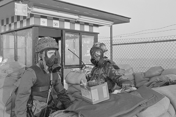 RNZAF Flight Lieutenant Ken Cunningham (right) and a soldier wearing gas masks at a guard post during a Scud missile alert at King Khalid International Airport, Riyadh, Saudi Arabia. Feb-Mar 1991. Image ref PD15-9-91, RNZAF Official.