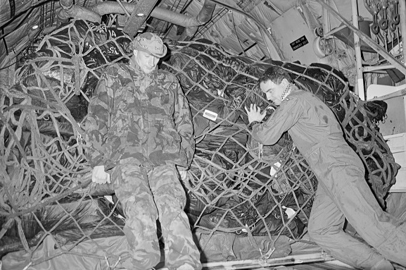 Operation Fresco. Flight Sergeant Stephen Skudder (right) and SSE Fred Bias (RAF) loading freight into the back of a No. 40 Squadron Hercules at King Khalid International Airport, Riyadh, Saudi Arabia. Feb-Mar 1991. Image ref PD18-24-91, RNZAF Official.