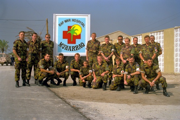 Group of New Zealand Defence Force Medical Contingent personnel, in front of a sign 