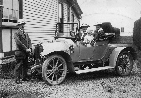 Canterbury Aviation Company Chief Flying Instructor, Cecil Hill standing at the front of a car with two women and a baby, at Sockburn Aerodrome, 1918. Image ref MUS9709010, Air Force Museum of New Zealand.