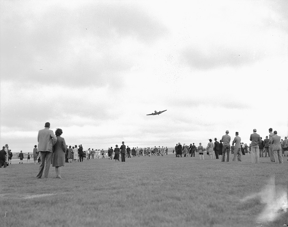 Meteor NZ6001 flying past members of the public during a display at RNZAF Station Ohakea during the tour of New Zealand by the aircraft, 7 April 1946. Image ref OhG384_46, RNZAF Official.