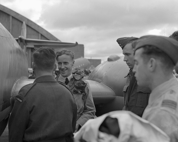 Squadron Leader RM McKay, being greeted by fellow servicemen at RNZAF Station Ohakea during his tour of New Zealand with Gloster Meteor NZ6001, 7 April 1946. Image ref OhG386_46, RNZAF Official.