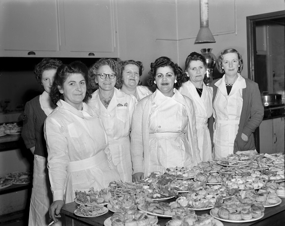 Group of catering staff with food ready for the tables at the Victory Ball.  RNZAF Station, Rongotai, September 1945. Image ref PR7393, RNZAF Official.